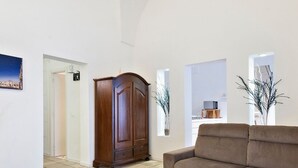 Una sala de estar con un sofá, un aparador de madera y un cuadro enmarcado en la pared.