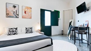 A modern bedroom with a bed, a desk with a chair, and two paintings on the wall. - Obelisk Studio - Lecce Selection (Lecce)
