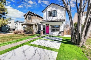A two-story house with a well-maintained lawn and a driveway.