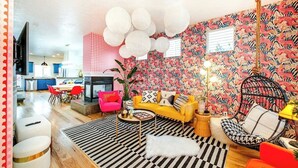 A modern living room with a sofa, chairs, a dining area, and a kitchen in the background. - The Audacity Boise - BSU -Close to eveything ! (Boise)