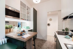 A modern kitchen with a built-in oven, a dining area with a wooden table, and a kitchen island.