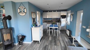 A modern kitchen with white cabinets, a built-in oven, and a stove. - Vacation home "Im Wäldchen" near the lake for couples and families with pets (Templin)