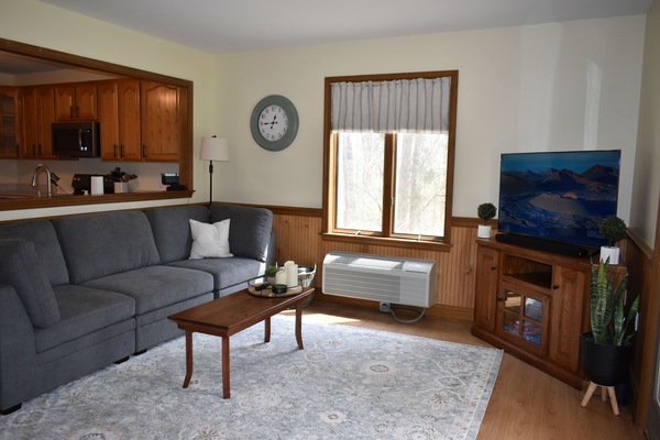 Living room with smart TV and surround sound speakers.