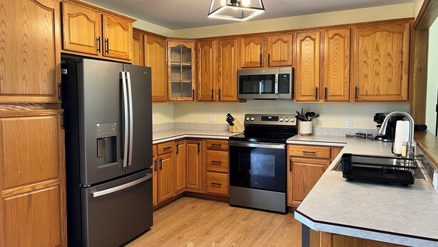 A modern kitchen with wooden cabinets, stainless steel appliances, and a built-in oven. - The Cozy Cottage! Private 1-bedroom cottage in a peaceful setting in Ottsville (ottsville)