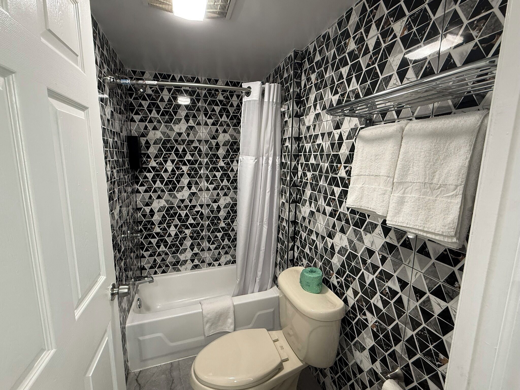 Un baño con bañera, inodoro y cortina de ducha.