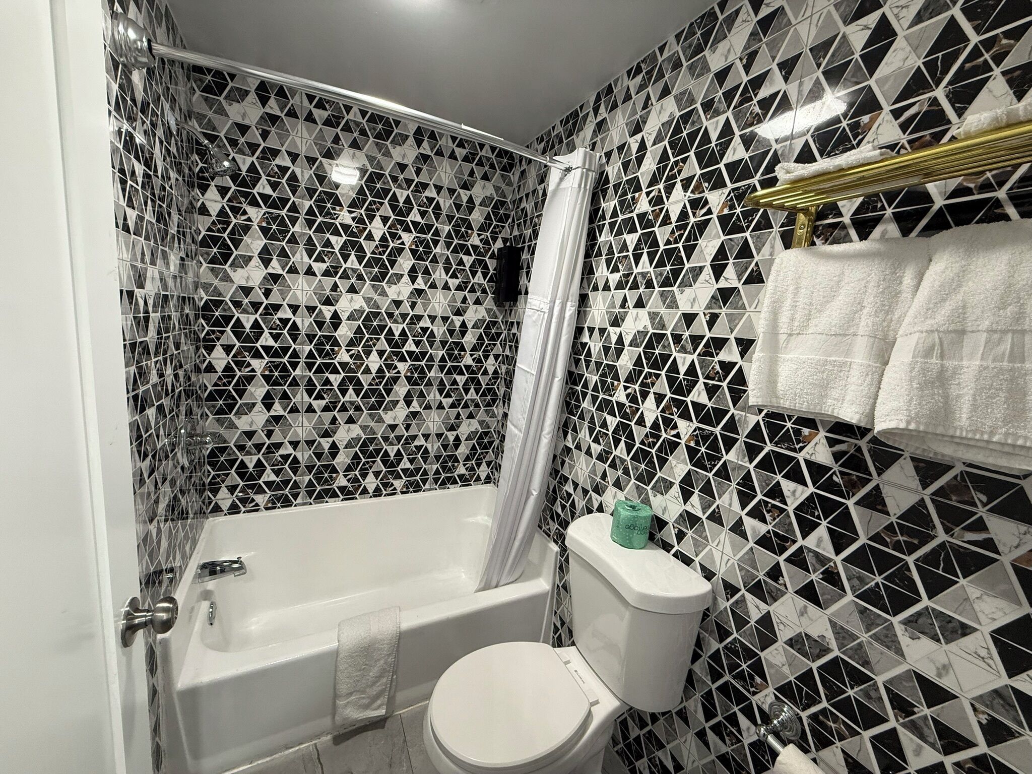 Un baño con bañera, inodoro y cortina de ducha.