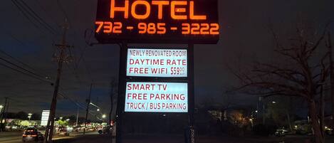 A sign for the Beauty Rest Hotel with amenities including a newly renovated room, free WiFi, smart TV, free parking, and truck/bus parking.