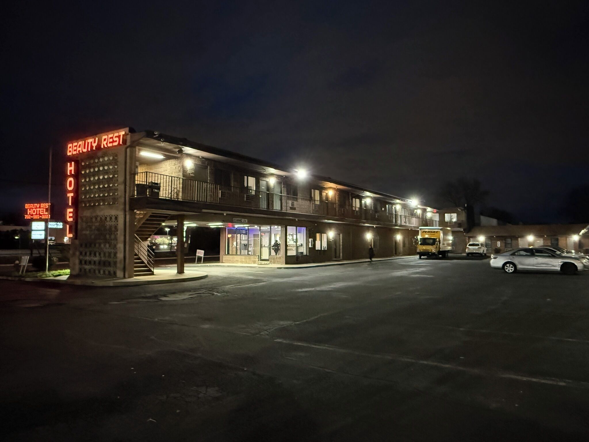 Un motel de dos pisos con un letrero que dice "Beauty Rest Hotel".