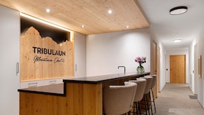 Una cocina moderna con una isla de madera, taburetes de bar y un cartel que dice 'TRIBULAUN Mountain Chalet'.