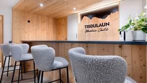 Un interior de madera con una mesa de recepción, sillas y una planta en maceta.