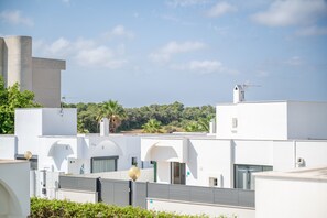 Un edificio moderno con paredes blancas, varias ventanas y techo plano.