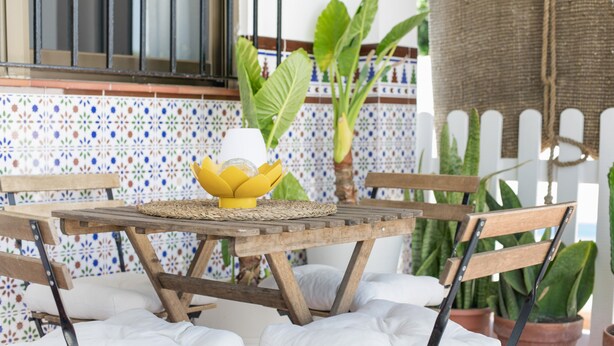 A wooden table with a woven placemat, a yellow bowl with a white object, and a potted plant. - Holiday Home 'Castro' with Mountain View, Wi-Fi and Air Conditioning (Vejer de la Frontera)