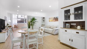 A modern living room with a dining area, white furniture, and a large window. - 'Suite 1 San Agustin' with Wi-Fi (Icod de los Vinos)