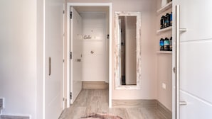 A hallway with a door labeled 'Calceena,' a mirror, and a shelf with bottles.