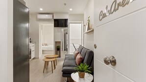 A modern living area with a sofa, a small round table, and a potted plant. - La Cala Home - Cala Arena - Ground Floor Studio with Private Patio and Pool (La Cala de Mijas)