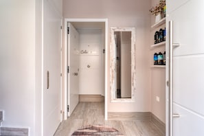 A hallway with a door labeled 'Calceena,' a mirror, and a shelf with bottles.