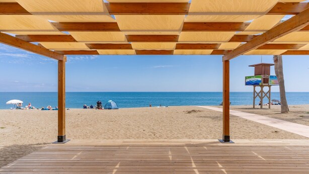 A wooden beach deck with a view of the ocean and beachgoers. - La Cala Home - Cala Arena - Ground Floor Studio with Private Patio and Pool (La Cala de Mijas)
