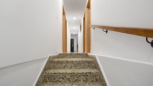 A staircase with a terrazzo finish leading to a room with white walls and a wooden handrail. - Vacation Studio 'Estudio San Agustín 45' with Wi-Fi (Icod de los Vinos)