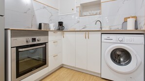 A modern kitchen with a built-in oven, a washing machine, and a coffee maker. - Vacation Studio 'Estudio San Agustín 45' with Wi-Fi (Icod de los Vinos)