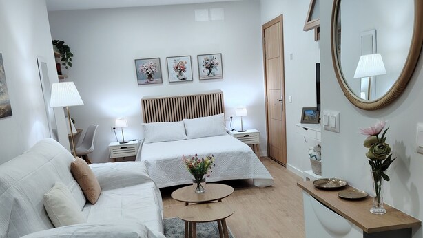 A modern hotel room with two beds, a small table, a mirror, and a wooden dresser. - Vacation Studio 'Estudio San Agustín 45' with Wi-Fi (Icod de los Vinos)