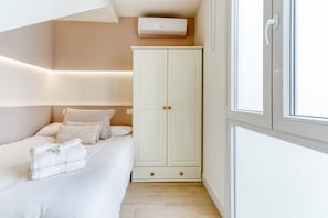 Une chambre à coucher avec un lit, une armoire et une fenêtre.