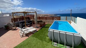 A rooftop terrace with a swimming pool, outdoor seating, and a view of the ocean. - Vacation Home 'Olas De Plata' with Sea View, Private Pool and Wi-Fi (Playa del Hombre)