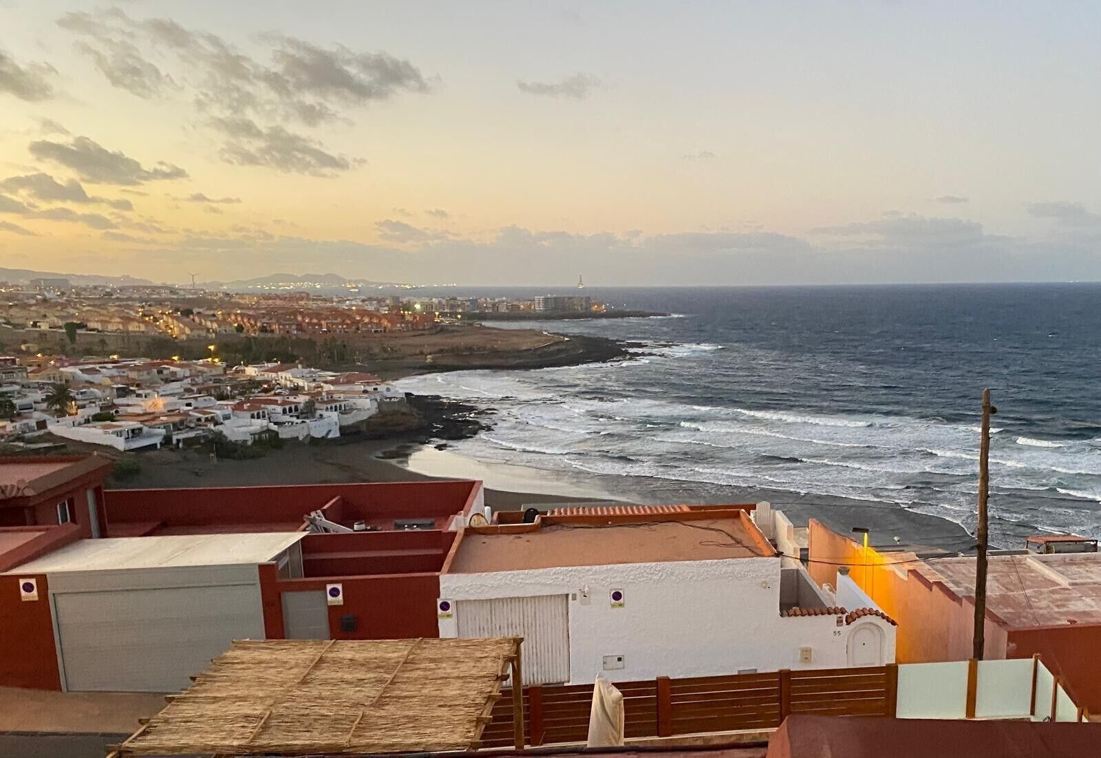 Un pueblo costero con edificios a lo largo de la costa, una playa y el océano.