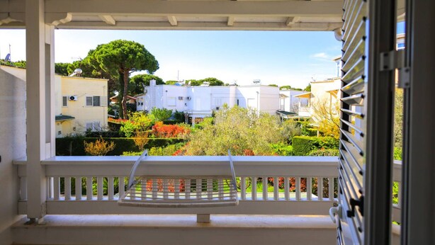 Un balcon donnant sur un quartier résidentiel, avec vue sur les maisons et la végétation.