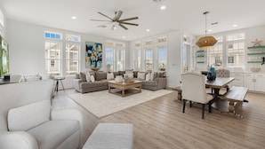 A spacious living room with a large sofa, a coffee table, and a dining area with a table and chairs. - SBS700 Shared Resort Style Pools, Boardwalk to the Beach, Charcoal Grill (Port Aransas)