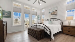 A bedroom with a bed, wooden bench, and a ceiling fan. - SBS700 Shared Resort Style Pools, Boardwalk to the Beach, Charcoal Grill (Port Aransas)