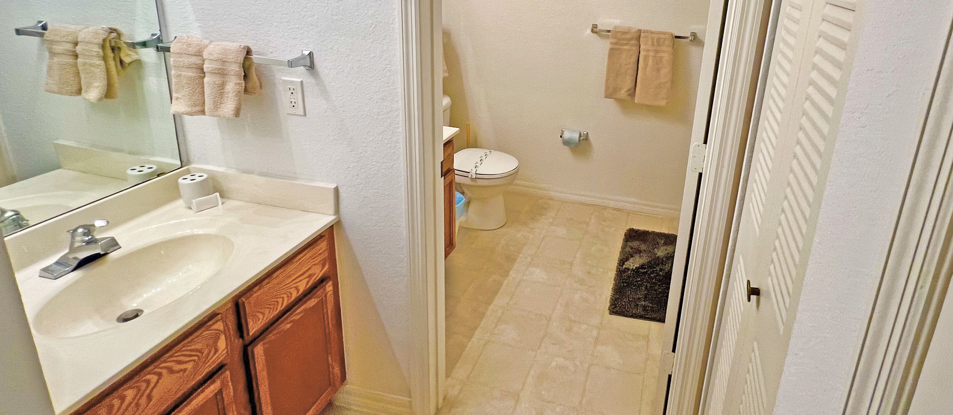 Une salle de bain avec un lavabo, un miroir et des toilettes.