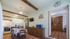 A kitchen with a dining table, chairs, a refrigerator, and a microwave. - Apartment Viola by Interhome (Gello)