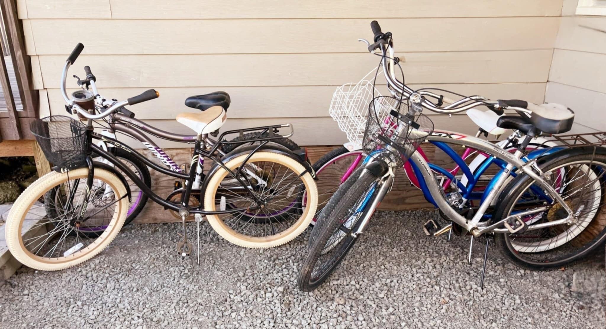 Three bicycles parked against a wooden wall.