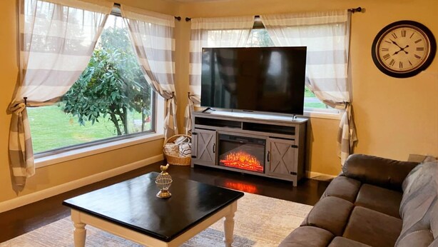 Una sala de estar con televisión, chimenea y sofá.