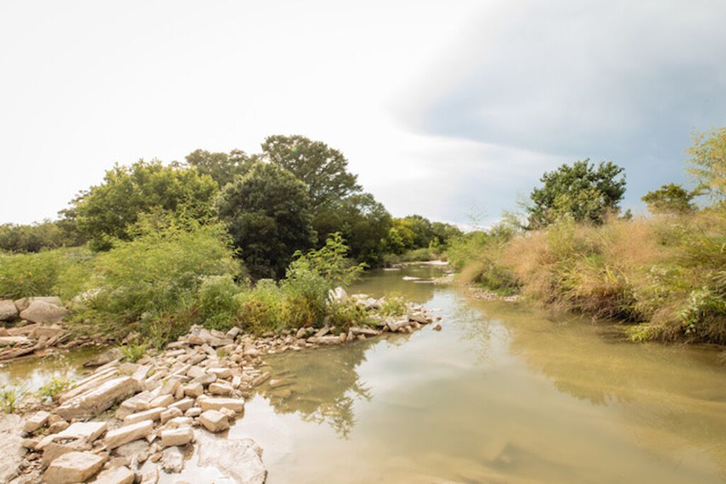 Une rivière bordée de rochers et de végétation.