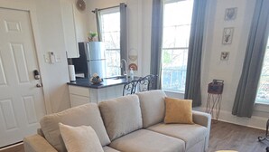 Una sala de estar moderna con un sofá modular, una mesita redonda y un plaid decorativo.