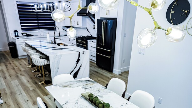 A modern kitchen with a marble countertop, white chairs, and a unique chandelier. - Charming waterfront 3-bedroom, 3 bath house with gourmet kitchen in Milton, FL (Milton)