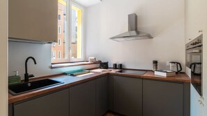 A compact kitchen with a window, a built-in stove, and a sink. - GuestHost - Rione Prati Apartment A (Rome)