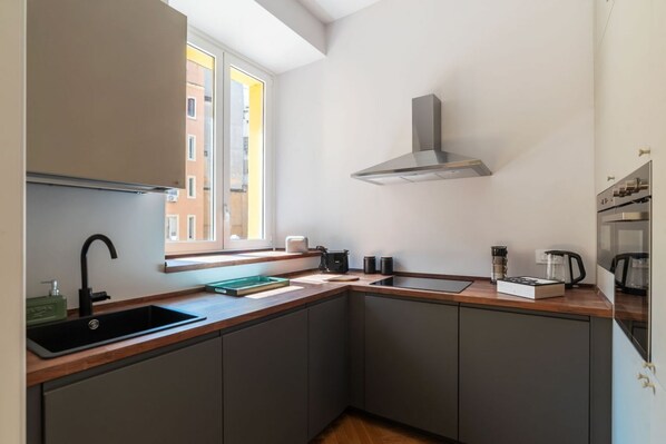 A compact kitchen with a window, a built-in stove, and a sink.