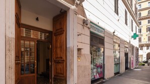 A building with a wooden door and a sign that reads 'FITOTERAPIA.' - GuestHost - Rione Prati Apartment A (Rome)