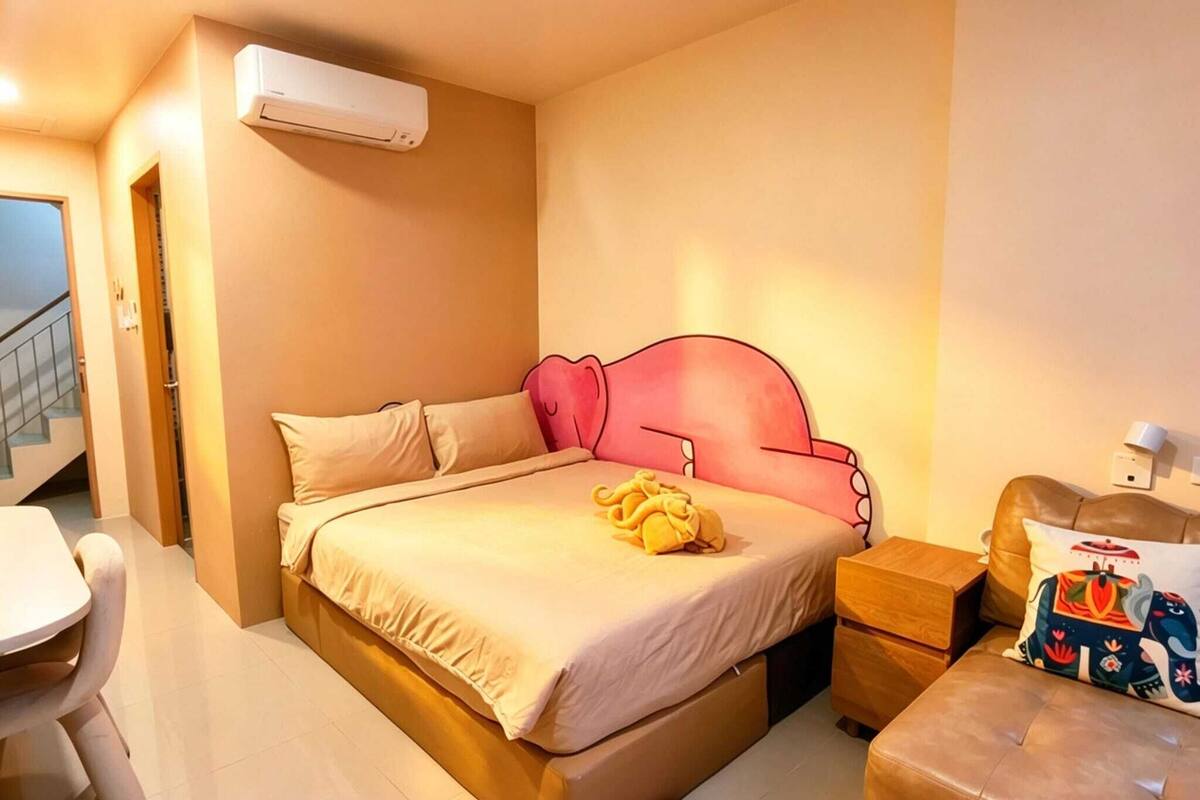 Un dormitorio con cama, mesita de noche y equipo de aire acondicionado.