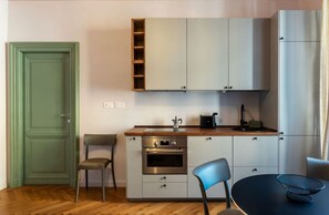 A compact kitchen with a built-in oven, a sink, and a wooden countertop. - GuestHost - Rione Prati Apartment B (Rome)
