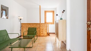 A room with a green sofa, a small table, a wooden cabinet, and a wooden partition.