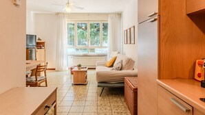 A compact living space with a kitchenette, a dining area, and a seating area with a sofa and a table. - Al Molo by Interhome (Domaso)