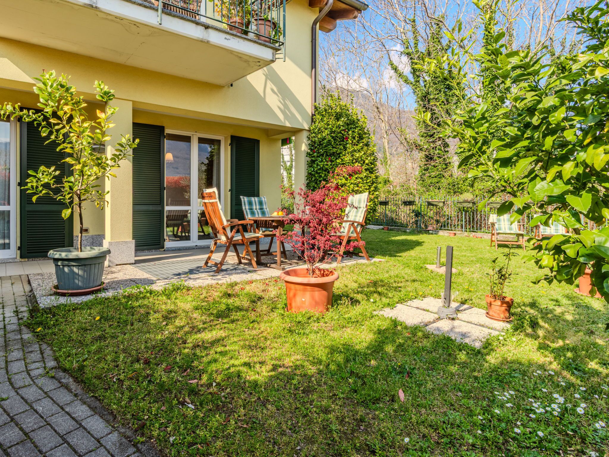 A residential property with a patio, outdoor seating, and a well-maintained garden.