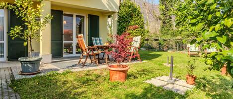 A residential property with a patio, outdoor seating, and a well-maintained garden.