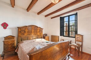 A bedroom with a wooden bed, a chair, a dresser, and a window with a view. - Teseo House | Lake View & Terrace, Gardone Riviera, Italy (Gardone Riviera)