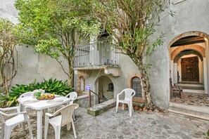 An outdoor seating area with a table, chairs, and a fruit basket. - Teseo House | Lake View & Terrace, Gardone Riviera, Italy (Gardone Riviera)