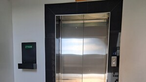 An elevator with a digital display, a sign indicating the 11th floor, and a caution sign for CCTV surveillance. - RnM Haven in Tsavo Apartments 13kms from JKIA
Walk to Stylish,Clean & Comfy Stay (Nairobi)