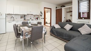 A compact living space with a kitchenette, dining area, and a sofa.